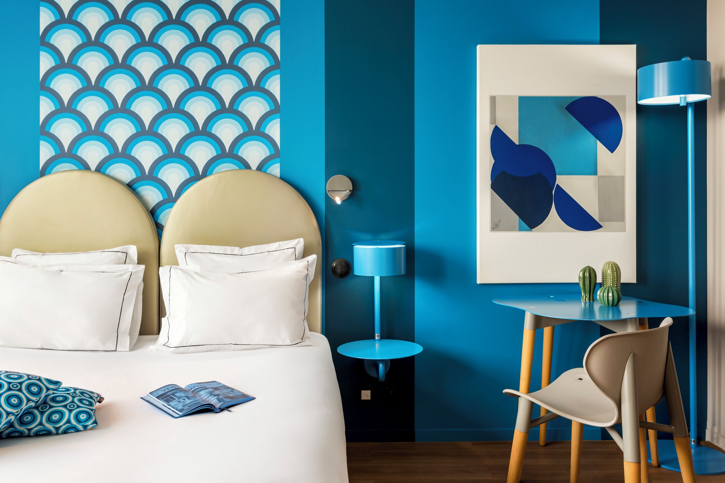 Une chambre d’hôtel moderne, équipée d’un lit, d’un bureau et d’une chaise.