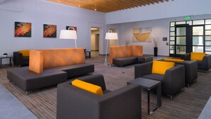 A modern lobby with sofas and chairs, a carpeted floor, and artwork on the walls. - Residence Inn Palo Alto Menlo Park (Menlo Park)