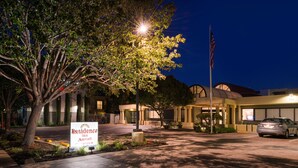 A hotel entrance with a sign, a flag, and a car parked in the driveway. - Residence Inn Palo Alto Menlo Park (Menlo Park)
