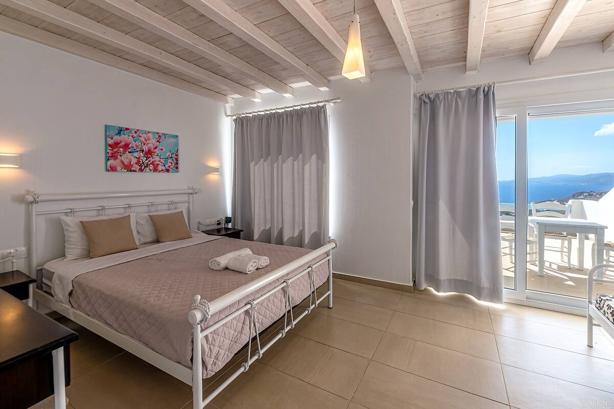 Un dormitorio con una cama, mesita de noche y un cuadro en la pared.