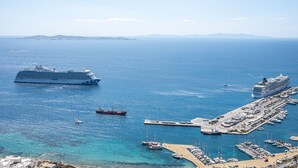 Un crucero amarrado en un puerto con un puerto deportivo y una pequeña isla con edificios.