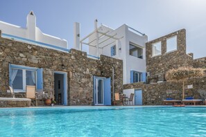 Una piscina al aire libre de temporada, sillones reclinables de piscina