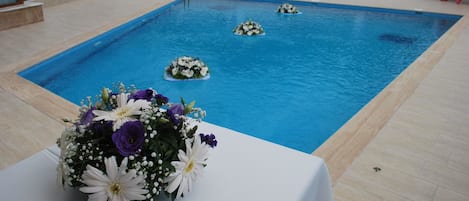 Una piscina al aire libre de temporada, sombrillas