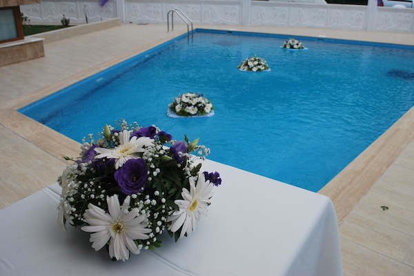 Una piscina al aire libre de temporada, sombrillas