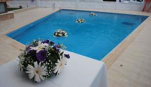 A pool with a white table and a floral arrangement. - Funda Otel Gocek (Fethiye)