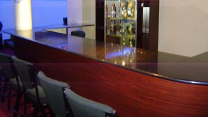Una zona de bar con mostrador y sillas de madera.