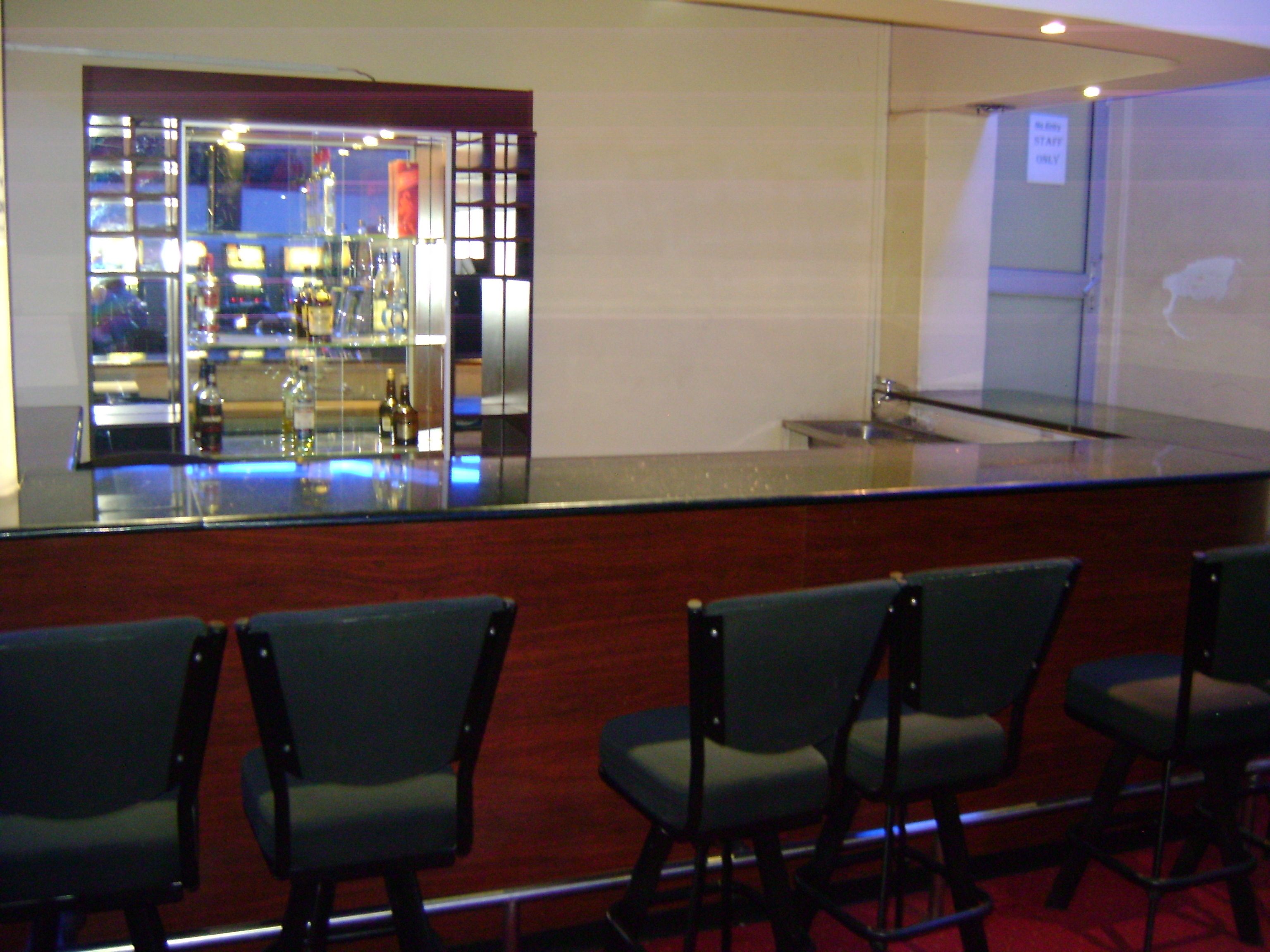 A bar area with a counter and several chairs.