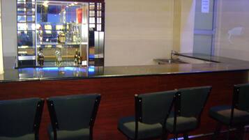 A bar area with a counter and several chairs.