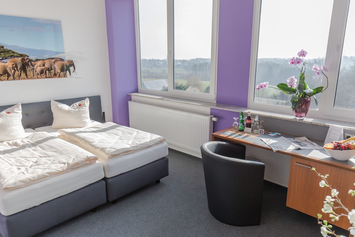 Un dormitorio con cama, escritorio y vistas al campo.