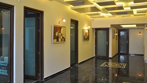 A modern hallway with a polished floor, framed artwork on the walls, and recessed lighting on the ceiling. - Malahit Exclusive City Hotel (Fethiye)
