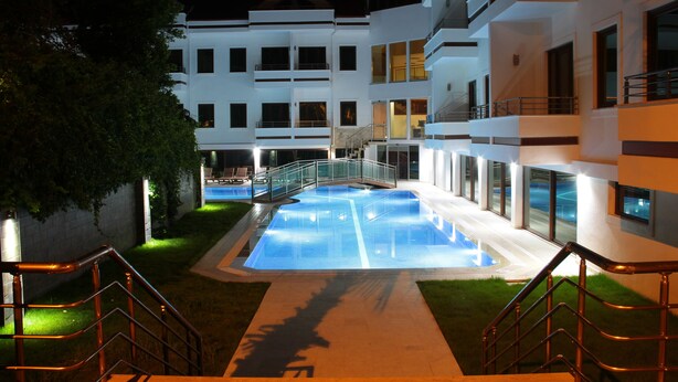 A modern hotel with a swimming pool, outdoor stairs, and a well-lit walkway. - Malahit Exclusive City Hotel (Fethiye)