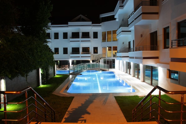 Alberca al aire libre, sombrillas en la alberca y camastros