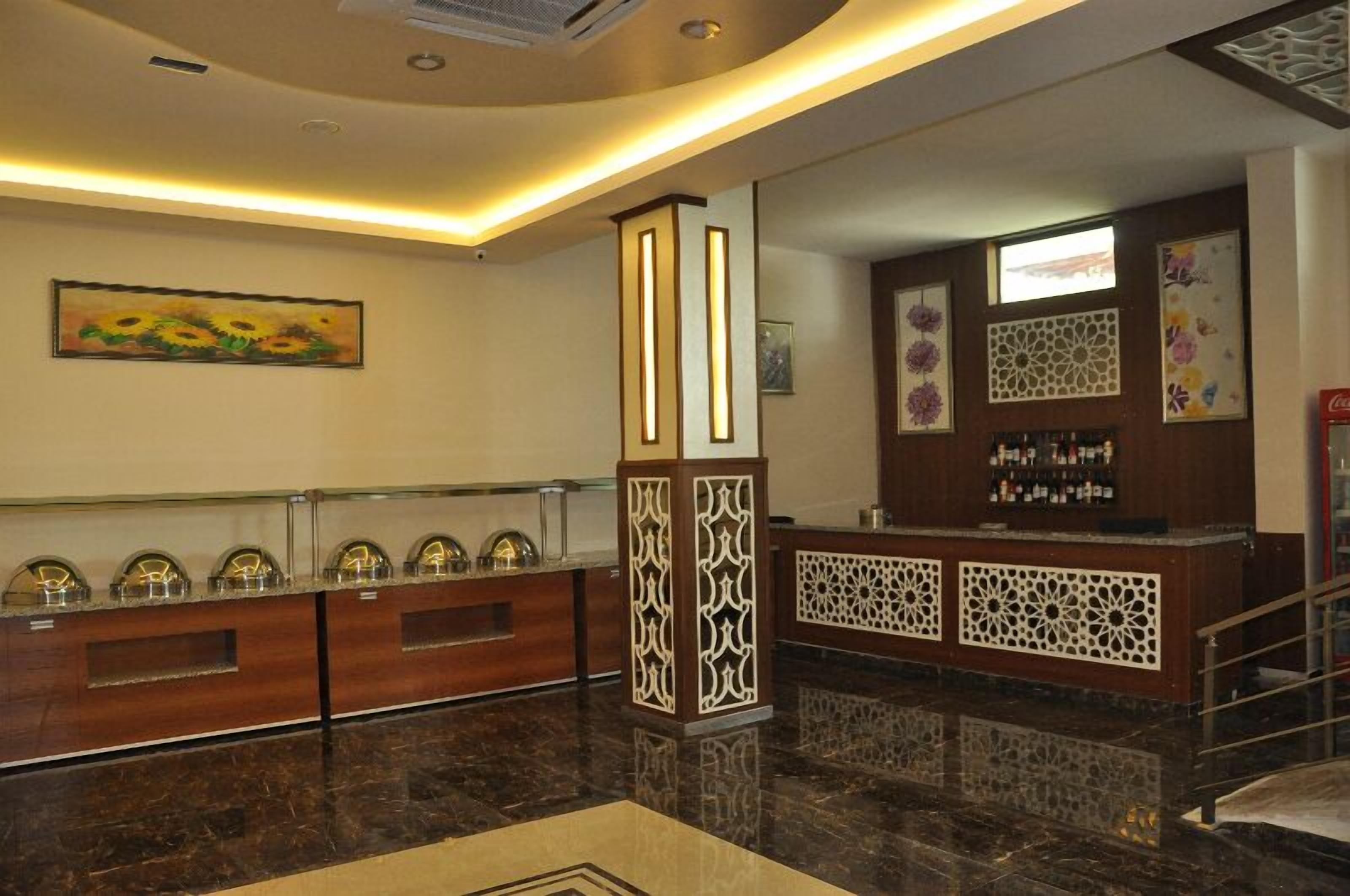 A reception area with a marble floor, a reception desk with a decorative screen, and a wall-mounted artwork of sunflowers.