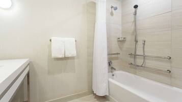 A modern bathroom with a bathtub, shower, and a toilet.