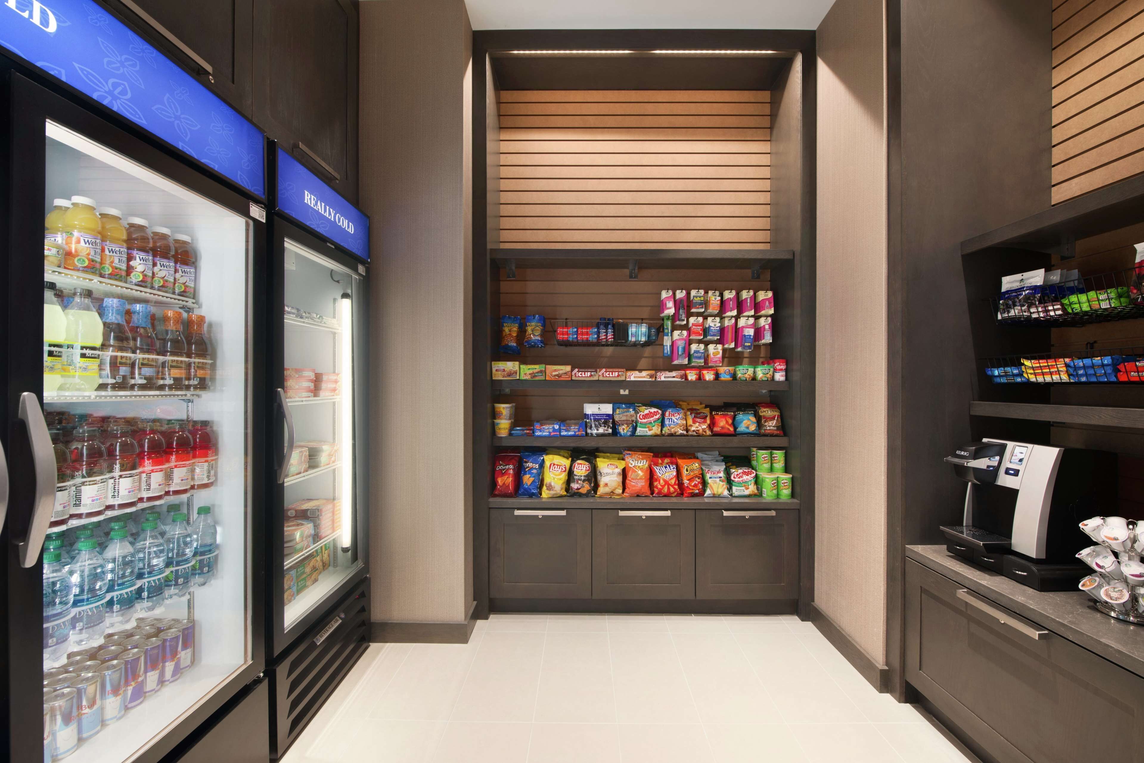 A refrigerated beverage area with a selection of drinks and snacks.