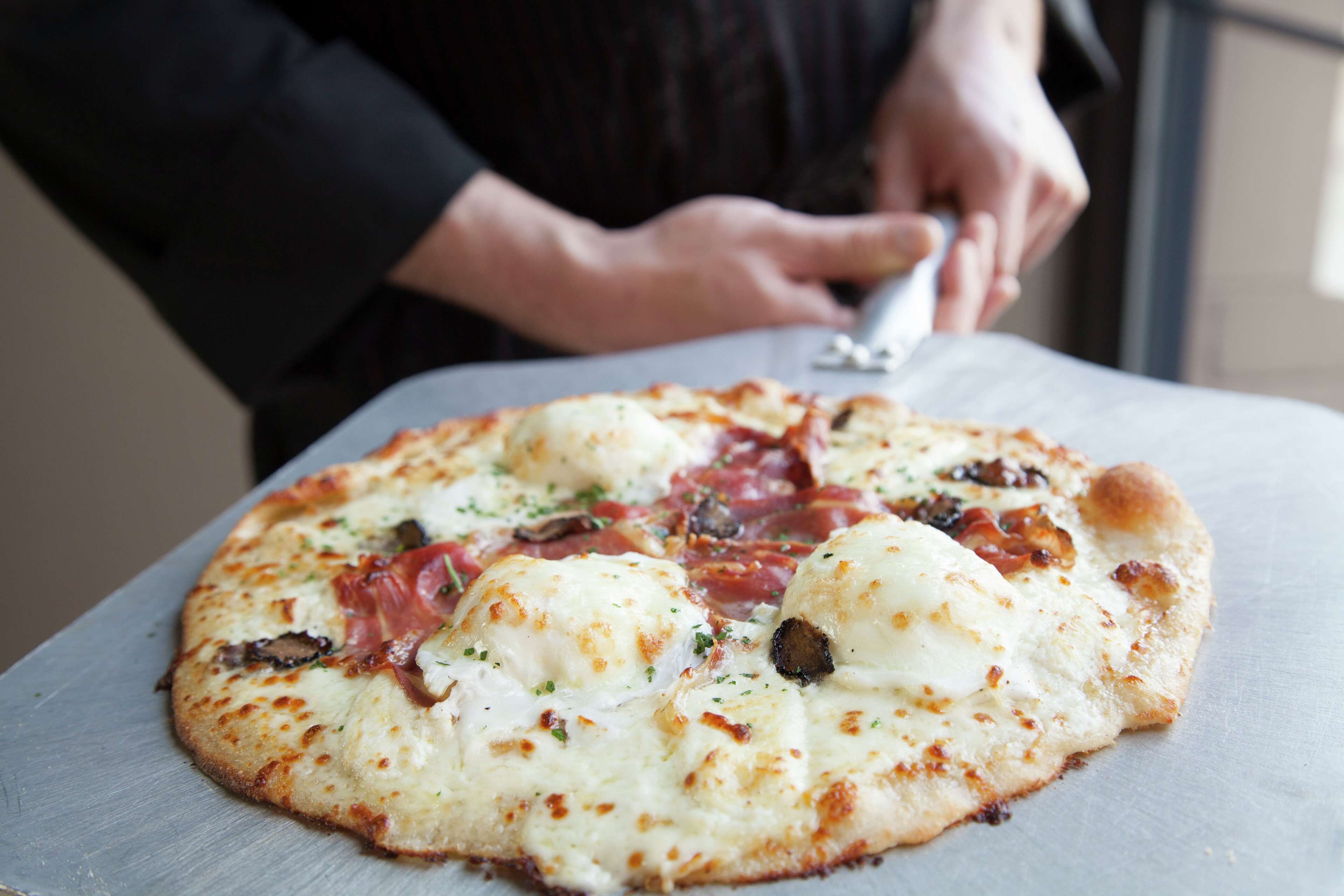 Une pizza garnie, posée sur une surface métallique.