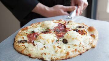 Une pizza garnie, posée sur une surface métallique.