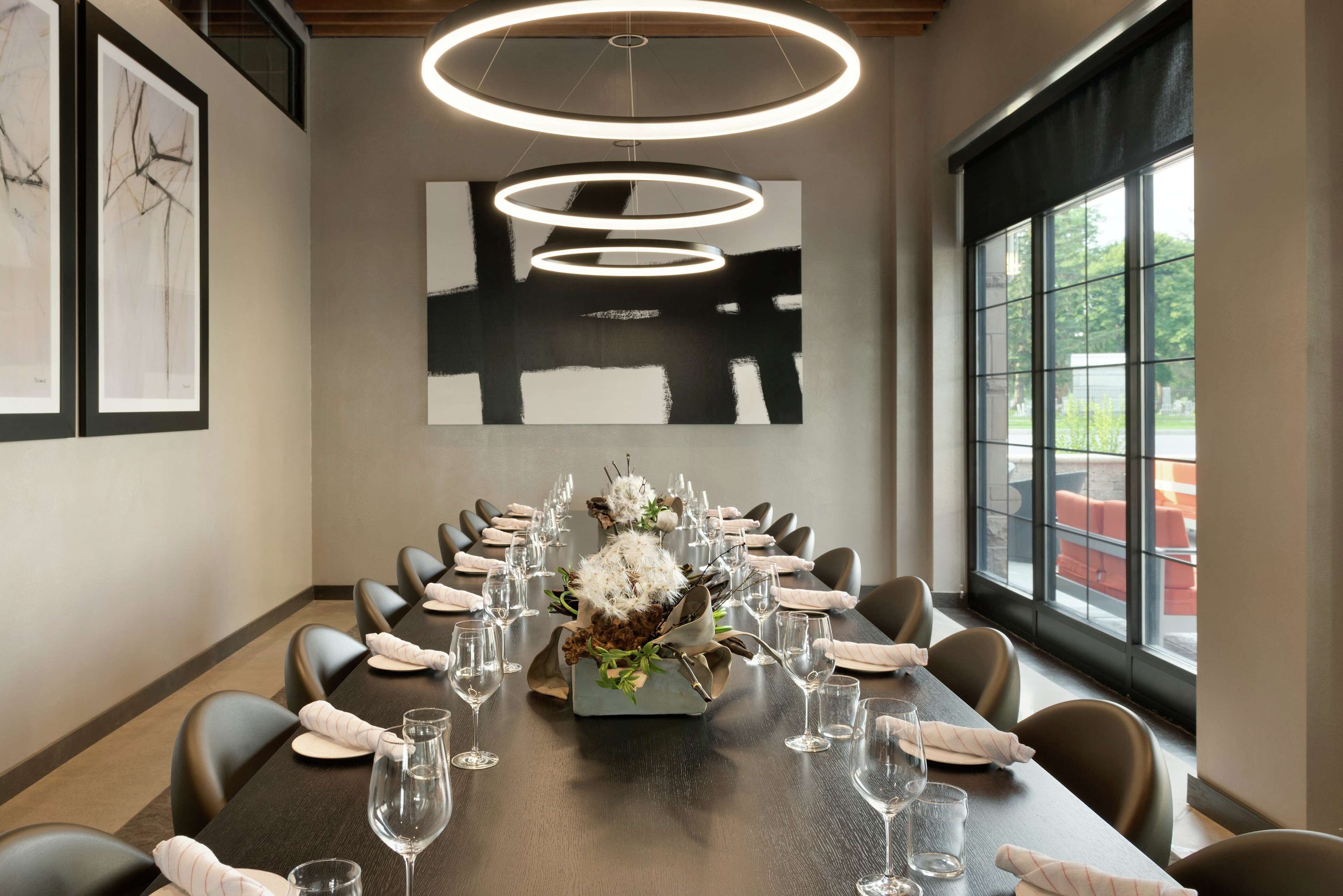 A conference room with a long table, chairs, and a floral centerpiece.