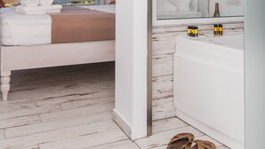A hotel room with a bed, a bathroom, and a view of greenery outside. - Stella Maria (Hersonissos)