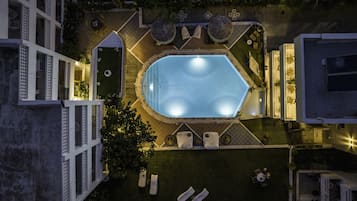 Una piscina al aire libre de temporada, sombrillas