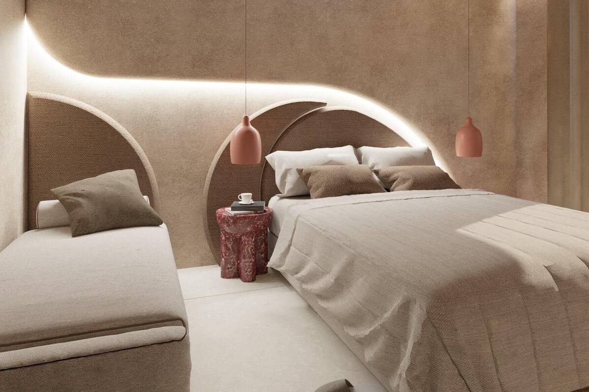 Ein modernes Schlafzimmer mit einem geschwungenen Kopfteil, einem Nachttisch und einem Bett mit einer gemusterten Decke.