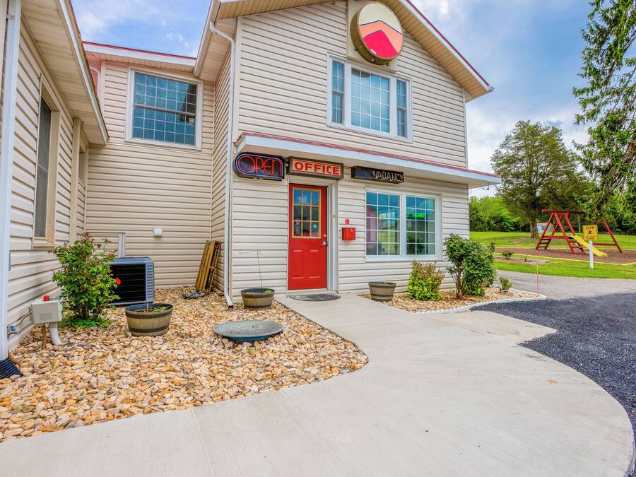 A two-story building with a red door, an 'OPEN OFFICE' sign, and a 'VACANCY' sign.