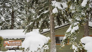 Un edificio cubierto de nieve con un letrero que dice 'Auberge Kicking Horse'.