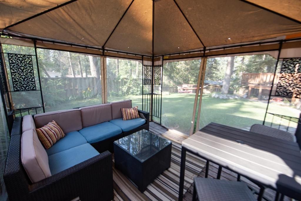 A covered outdoor seating area with a sofa and table.
