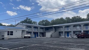 A motel with a central courtyard, multiple balconies, and a parking lot.