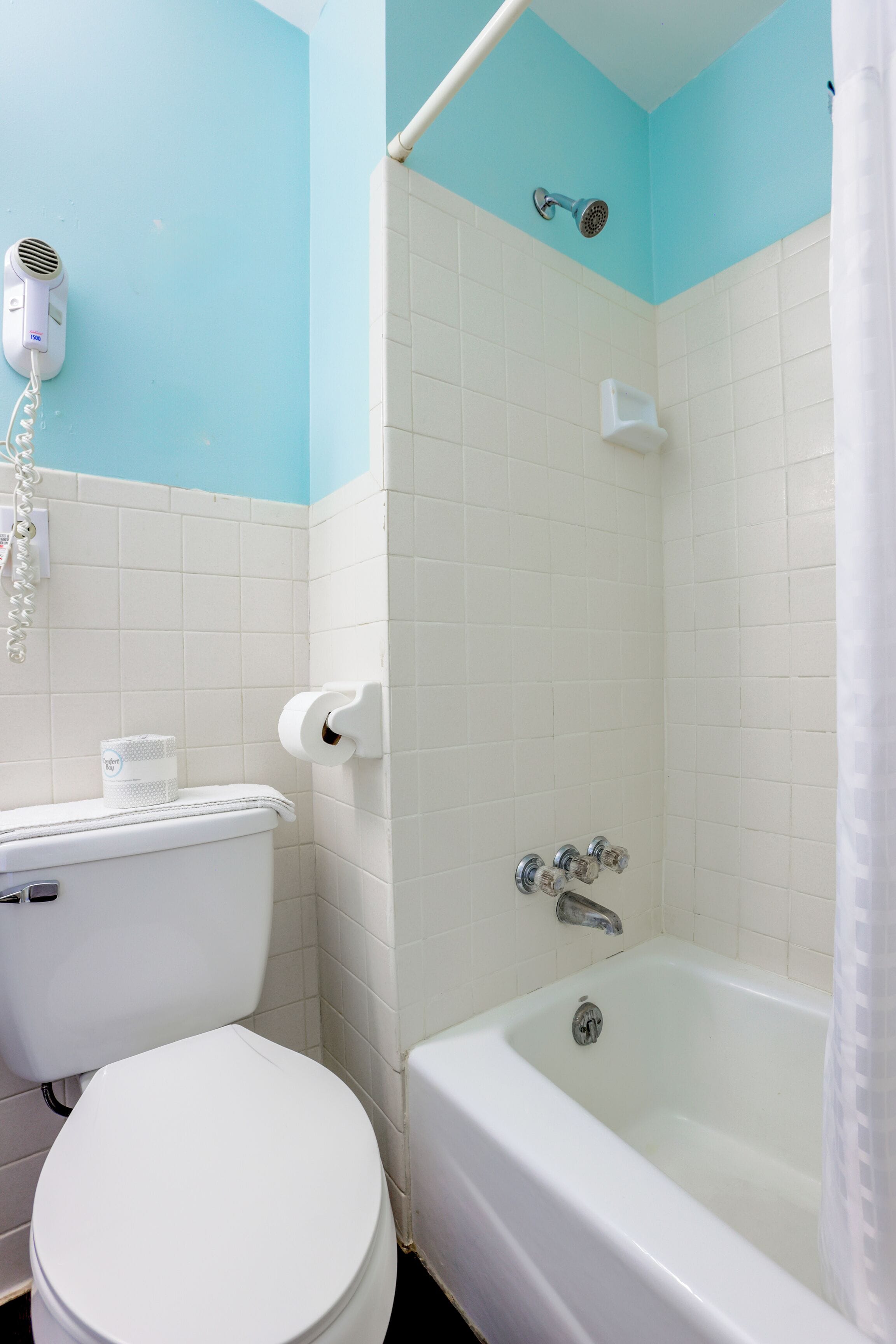 Een badkamer met toilet, douche en bad.