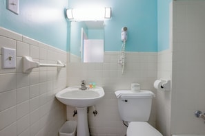 A bathroom with a sink, toilet, and hand dryer.