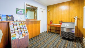 Zona de recepció amb un taulell de fusta, una màquina expenedora i un mirall penjat a la paret.