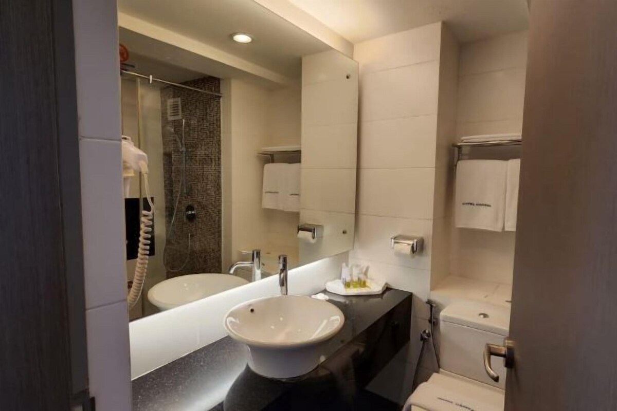 A modern bathroom with a double sink, a large mirror, and a shower area.