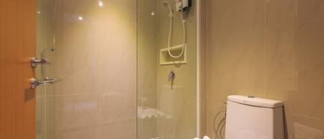 A modern bathroom with a glass-enclosed shower, a toilet with a white tank, and a patterned floor.