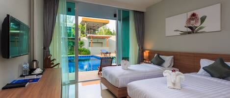 A hotel room with two beds, a desk, a TV, and a view of an outdoor swimming pool.