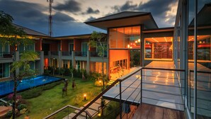 A modern building with a glass facade, a swimming pool, and a well-maintained garden. - Khaolak Forest Resort (Takua Pa)