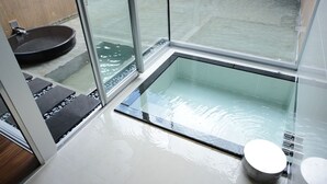 A modern bathroom with a glass-enclosed bathtub, a black circular sink, and a small toilet. - Four Seasons Yuzawa Quattro (Yuzawa)