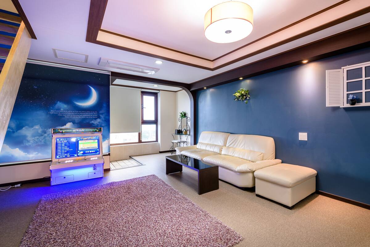 A modern living room with a white sofa, a coffee table, and a wall-mounted TV.