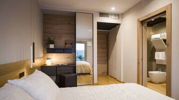 A modern bedroom with a bed, bedside table, and a large mirror.