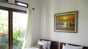 Habitación de hotel con dos camas, un cuadro en la pared y vistas a zonas verdes por la ventana.