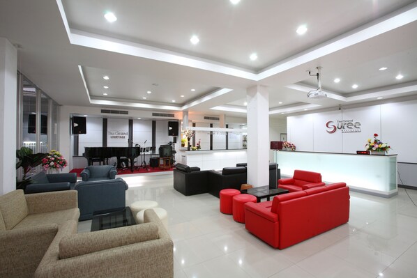 A modern lobby with seating areas, a reception desk, and a piano. - The Grand Suree Residence (Bangkok)