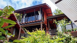 A two-story wooden house with a balcony, large windows, and a visible ceiling fan. - Alama Sea Village Resort (Ko Lanta)