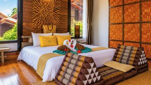 A hotel room with a bed, a window with a view, a woven wall, and a wooden floor. - Alama Sea Village Resort (Ko Lanta)