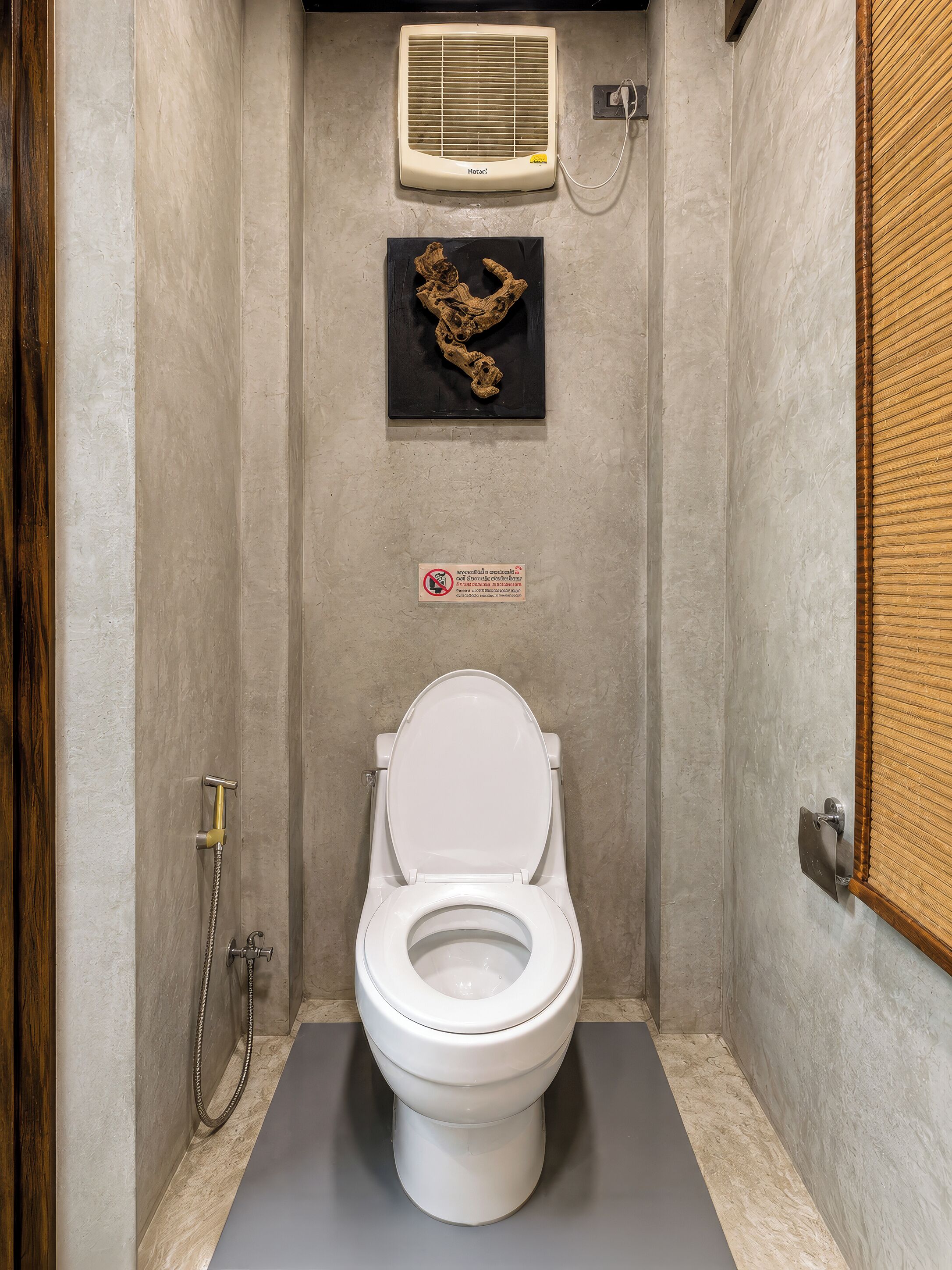 Un baño con inodoro blanco, ducha y aire acondicionado instalado en la pared.