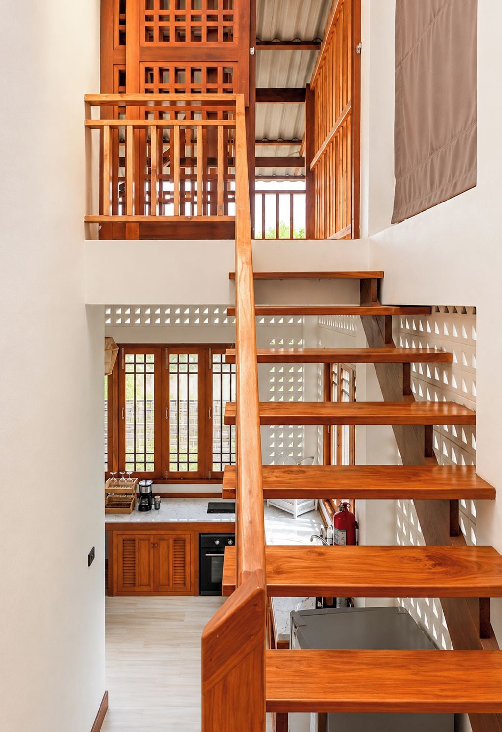 Una escalera de madera con vista a una cocina en la parte inferior.