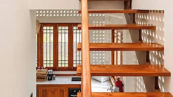 Una escalera de madera con vista a una cocina en la parte inferior.