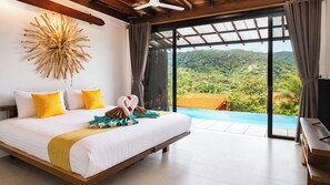 A bedroom with a large bed, a view of a lush landscape, and a ceiling fan. - Alama Sea Village Resort (Ko Lanta)