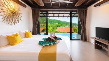 A hotel room with a bed, a flat-screen TV, and a view of a green landscape.