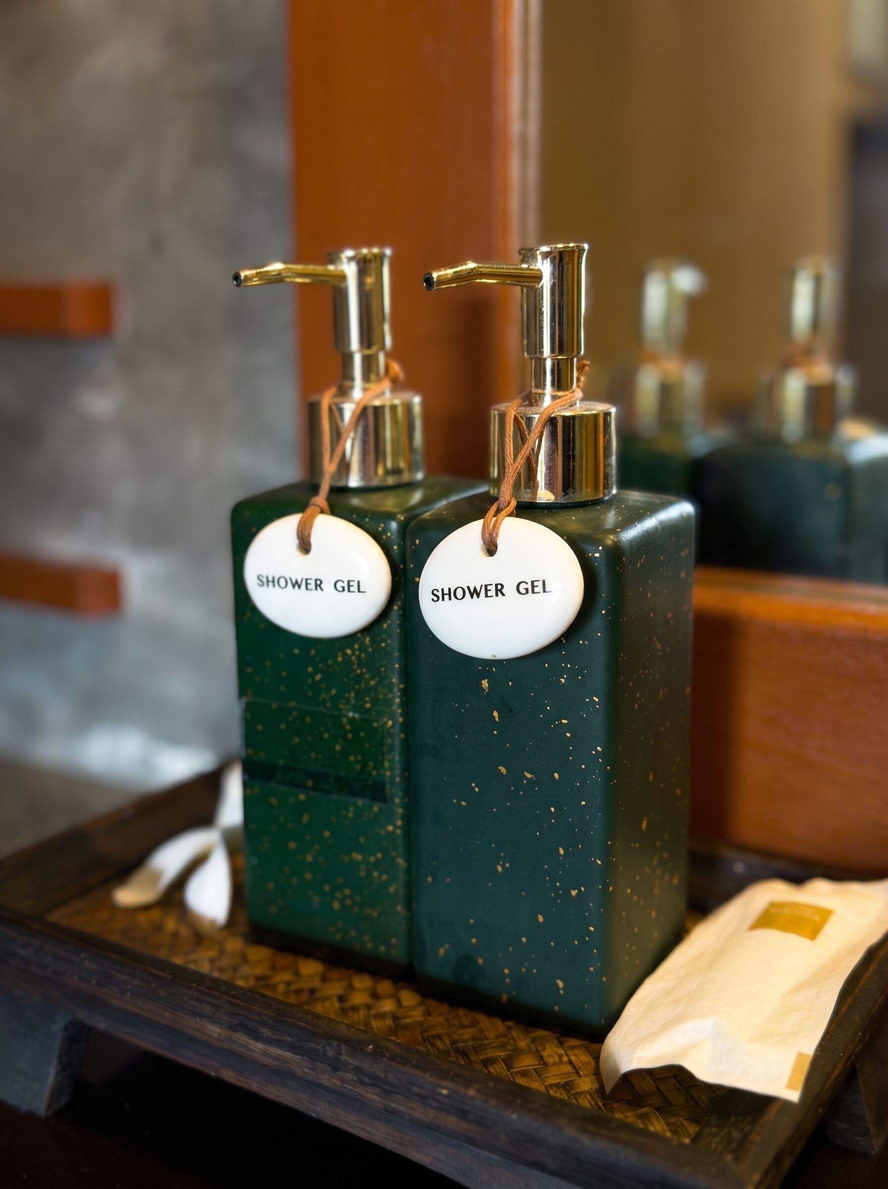 Two shower gel bottles with pumps on a tray.
