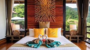 A hotel room with a bed, pillows, a wall art piece, and a view of the outdoors.